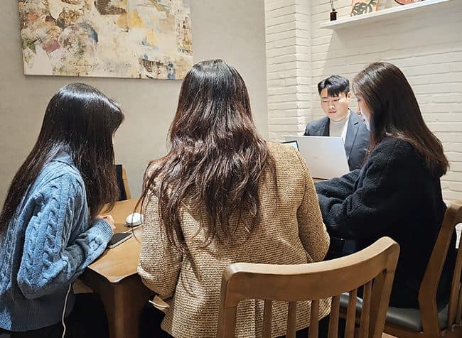 회의 중 화면의 자료를 짚어가며 설명하는 모습